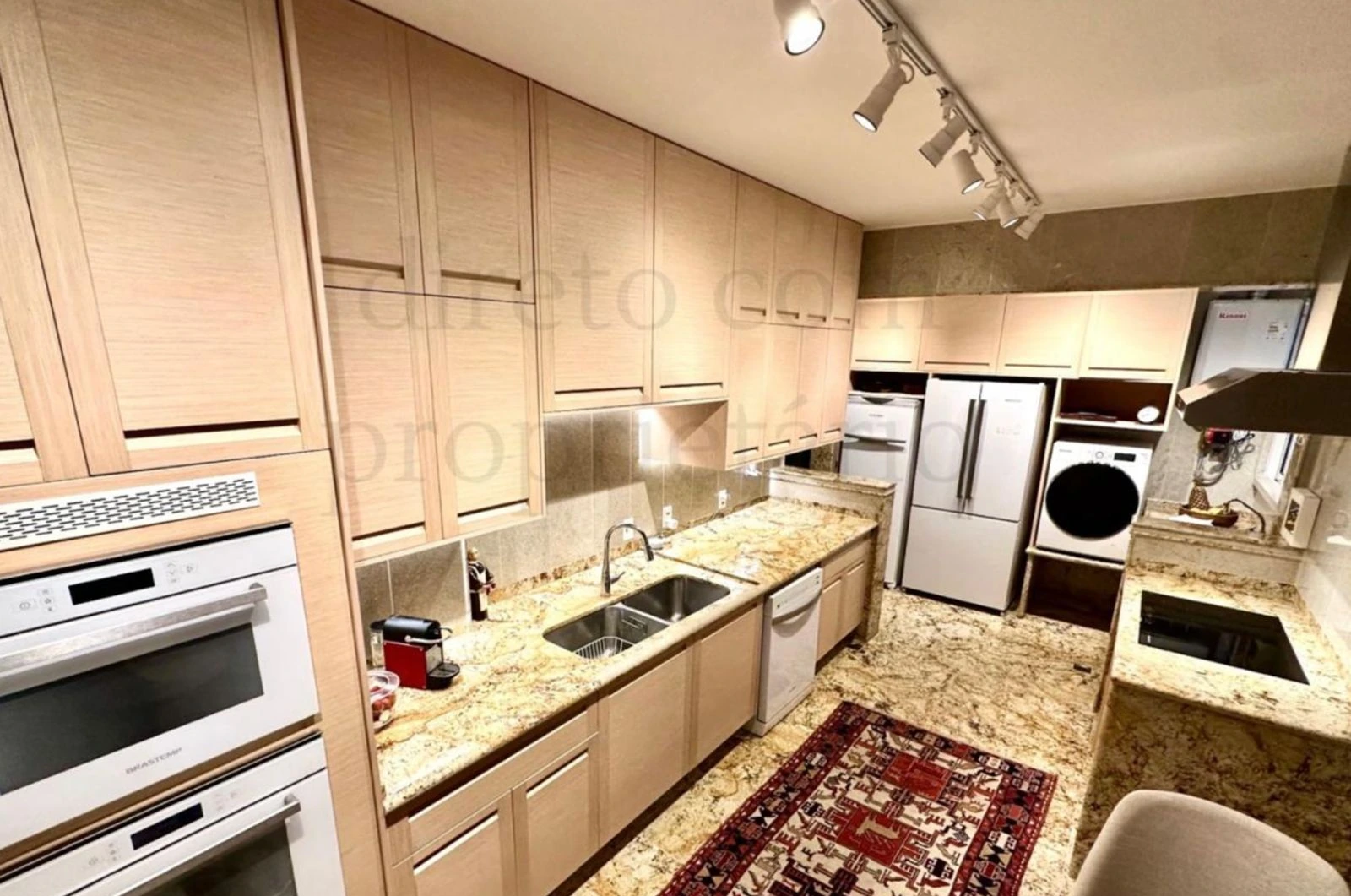 Apartment A Avenida Atlantica kitchen with light cabinetry and stone counters